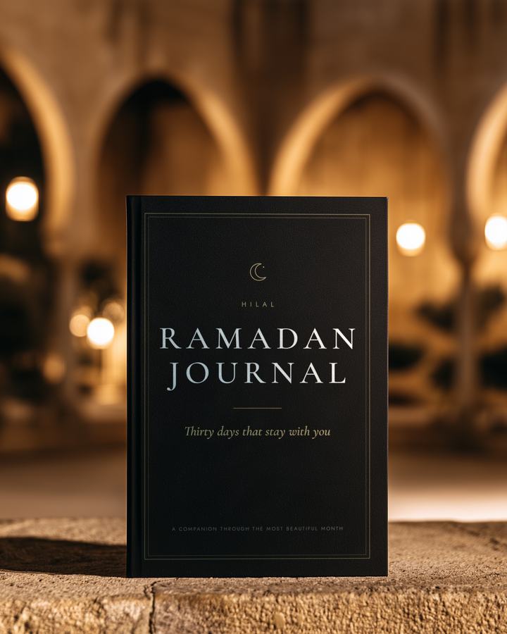 The Hilal Ramadan Journal standing in warm evening light in a mosque courtyard.